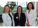 The three women who created this initiative are standing next to each other .